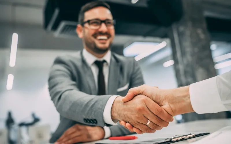 Businessman happily shaking hands with client