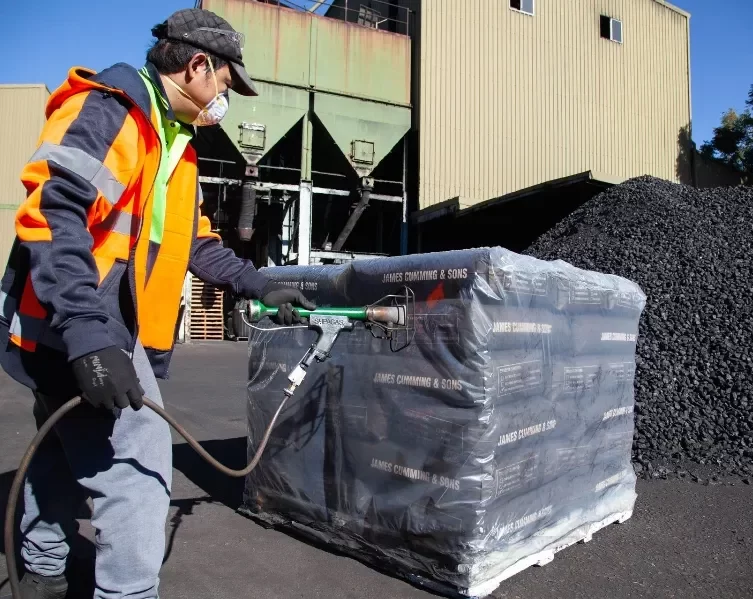 Worker vacuuming the plastic with sack of coal inside